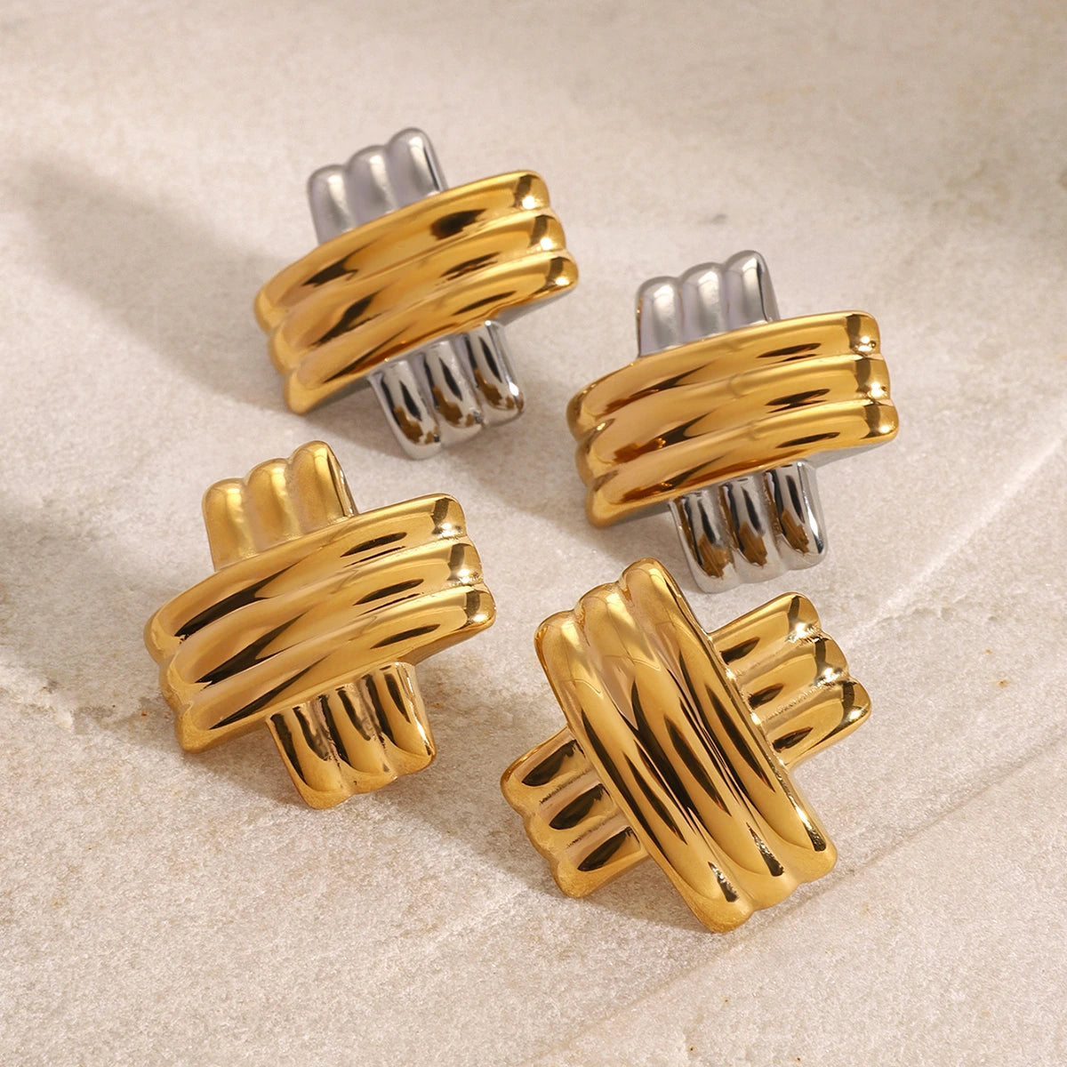 Set of gold and silver cufflinks on a beige surface
