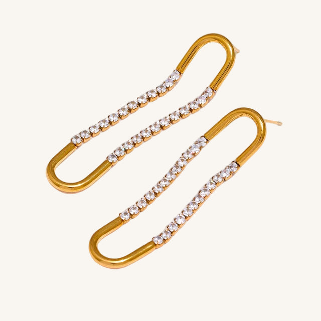 Gold earrings with clear gemstones on a white background