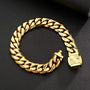 A thick gold Cuban link chain bracelet with a square sunburst-patterned clasp, displayed on a textured black surface.