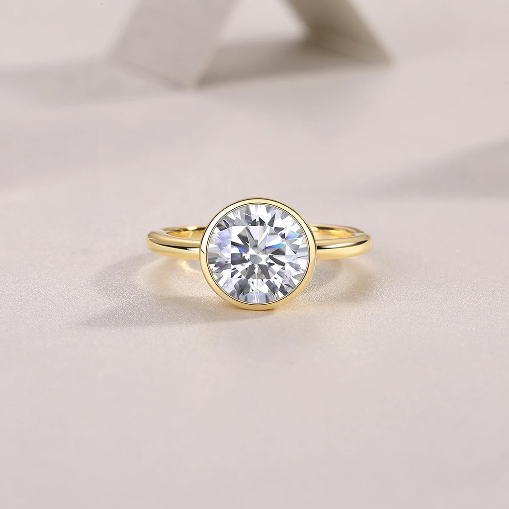 Gold ring with a large diamond on a light beige background