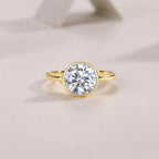 Gold ring with a large diamond on a light beige background