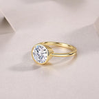 Gold ring with a large diamond on a light fabric background