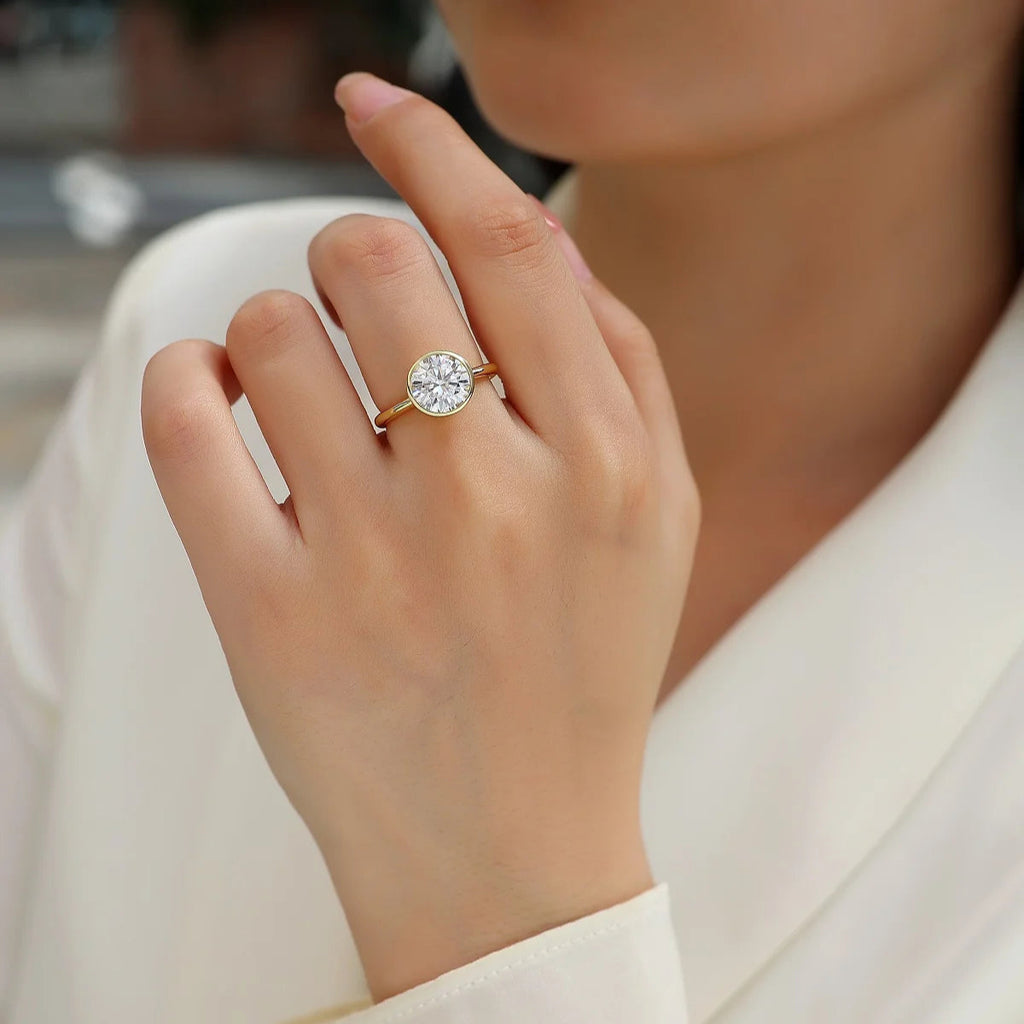 Close-up of a hand wearing a diamond ring with a blurred background