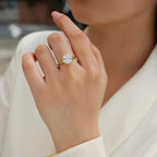Close-up of a hand wearing a diamond ring with a blurred background
