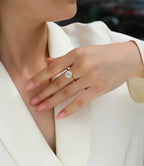 Close-up of a hand wearing a diamond ring with a blurred background