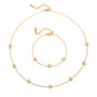 Gold necklace with small round beads on a white background