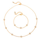 Gold necklace with small round beads on a white background