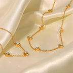 Gold necklace with small crystals on a beige fabric background