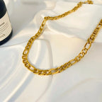 Gold chain necklace on a white fabric background