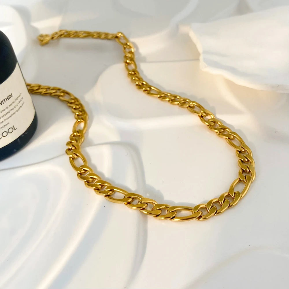 Gold chain necklace on a white fabric background