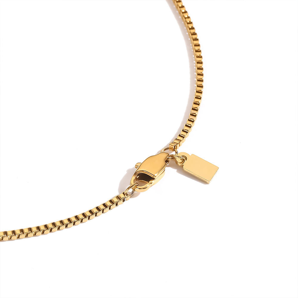 Gold chain necklace with clasp on a white background
