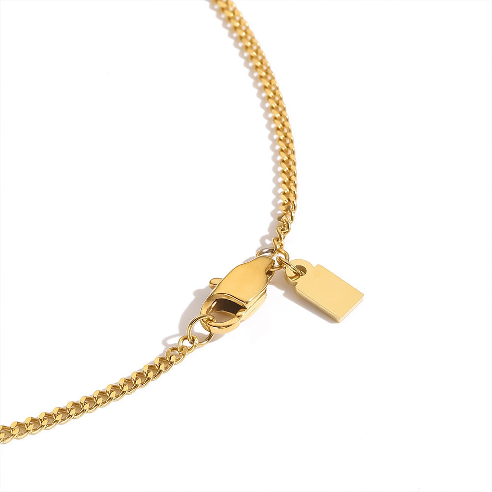 Gold chain necklace with a tag on a white background
