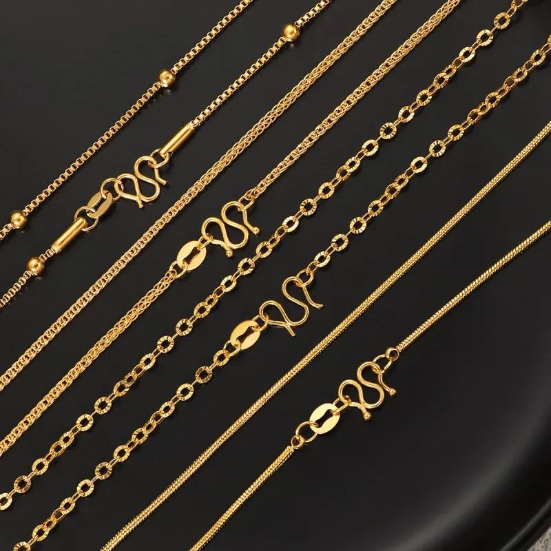 Gold chains of various designs on a black background
