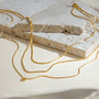 Gold necklace on a textured stone surface
