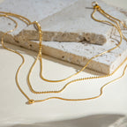 Gold necklace on a textured stone surface