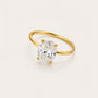 Gold ring with a large diamond on a light beige background