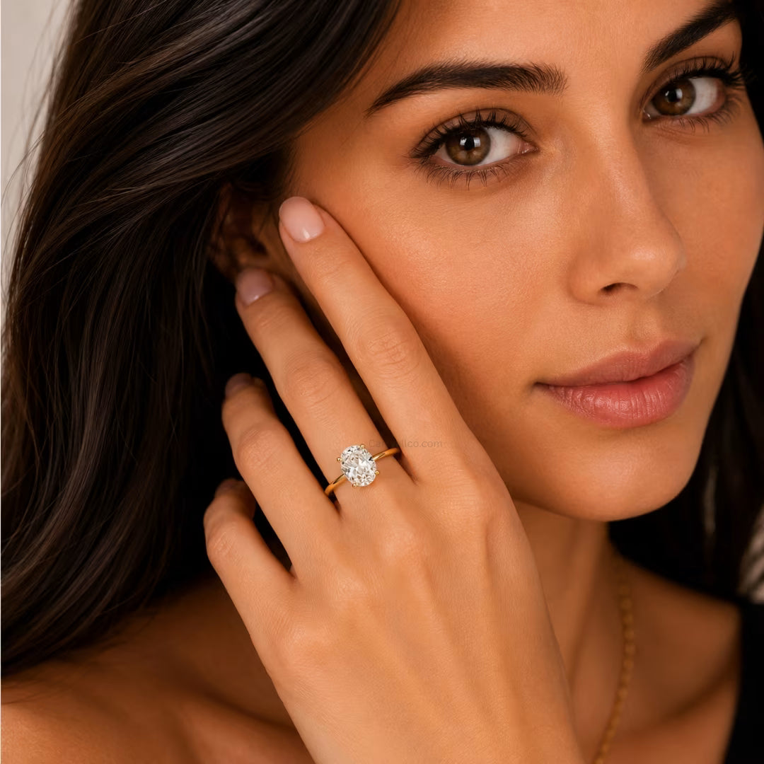 Woman wearing a diamond ring on her finger, close-up of face and hand.