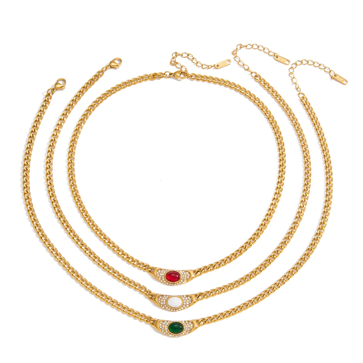 Set of gold necklaces with gemstone accents on a white background