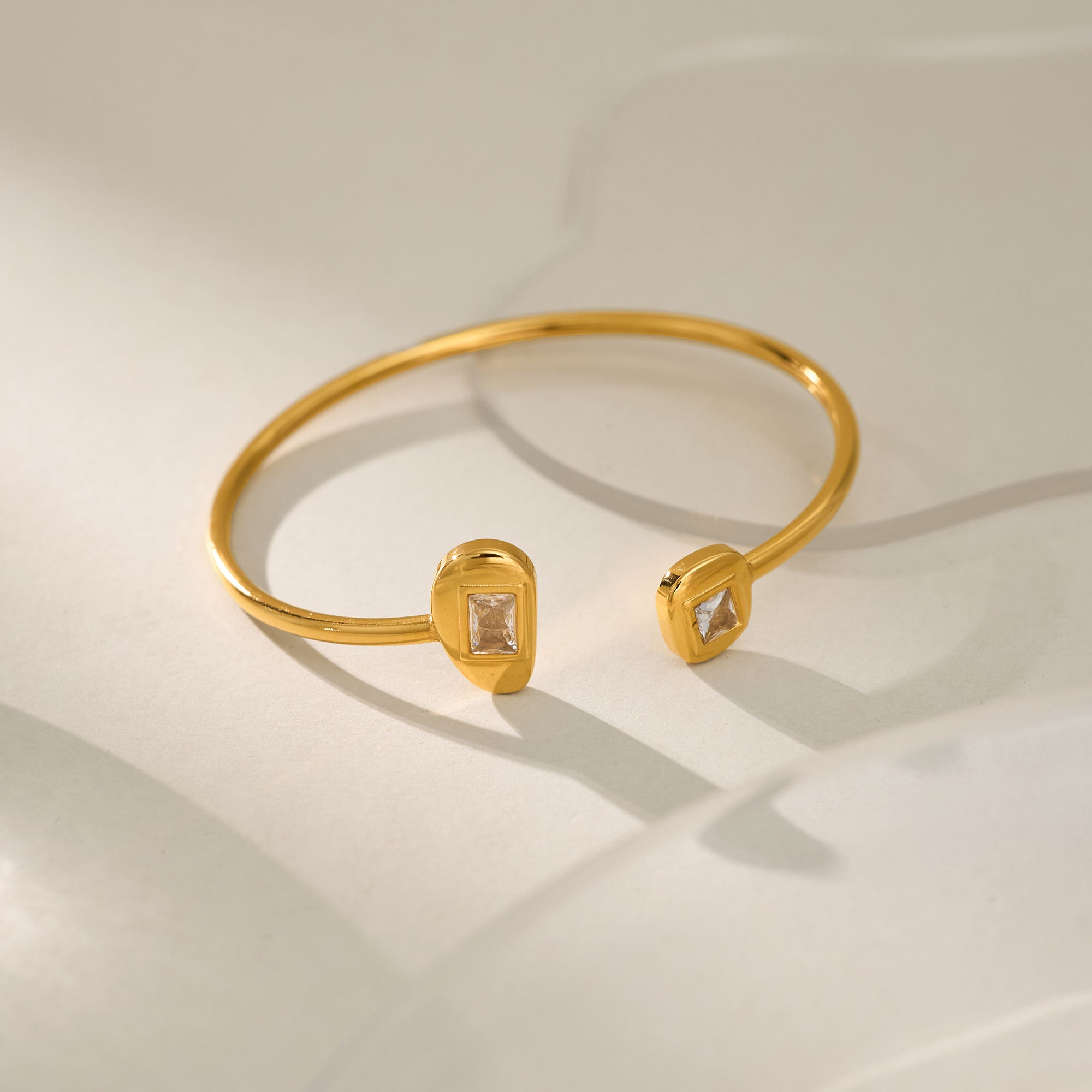 Gold bracelet with diamond-like stones on a light background