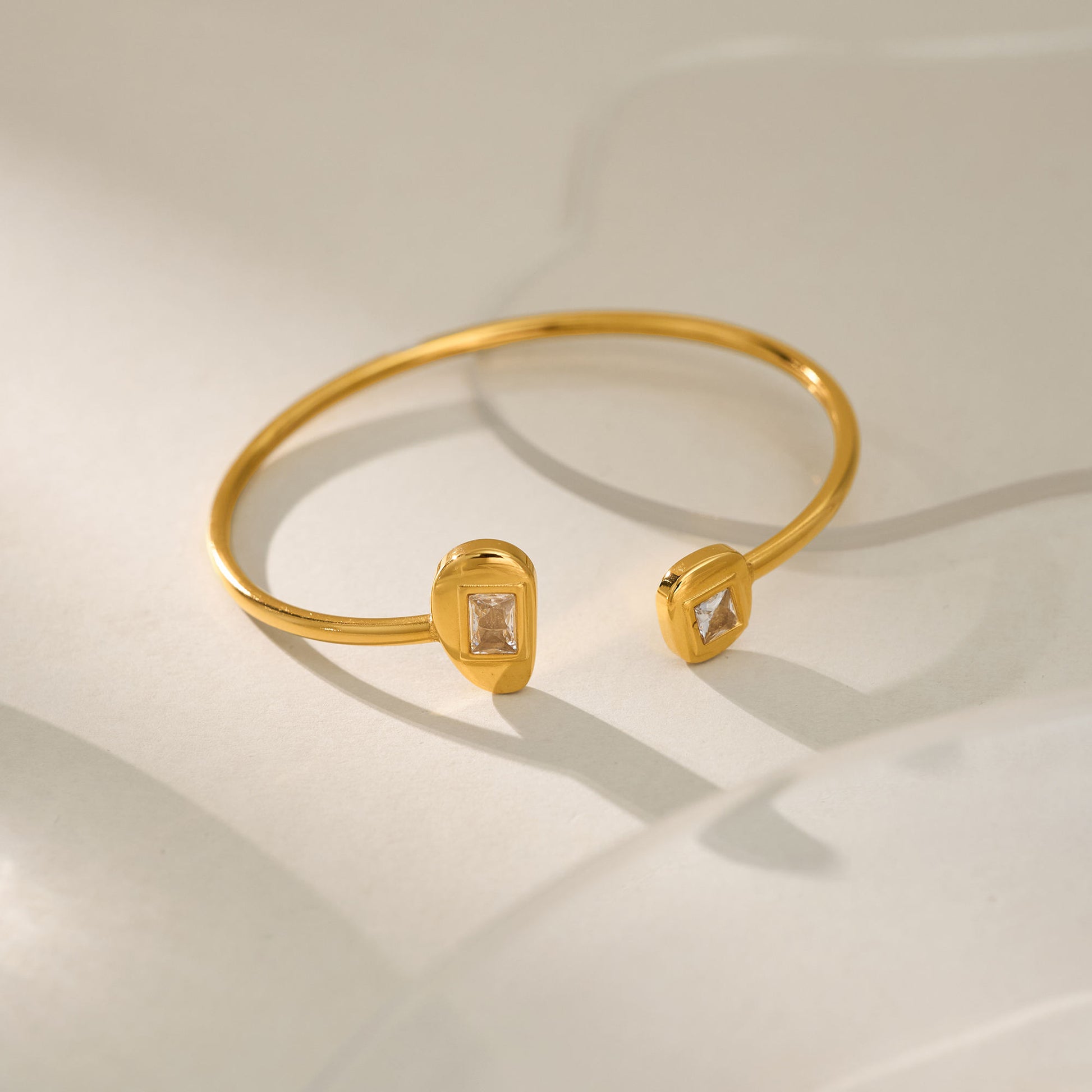 Gold bracelet with diamond-like stones on a light background