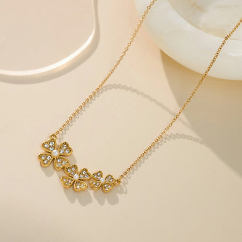 Gold necklace with butterfly-shaped pendants on a beige background