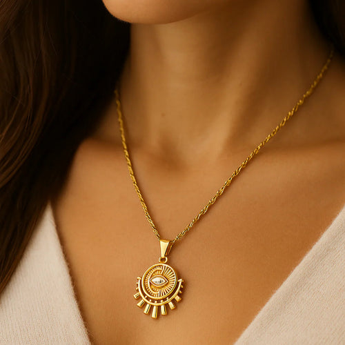 Close-up of a person wearing a gold necklace with a circular pendant.