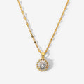 Gold necklace with a diamond pendant on a light gray background