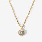 Gold necklace with a diamond pendant on a light gray background