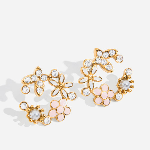 Gold floral earrings with pink accents on a white background
