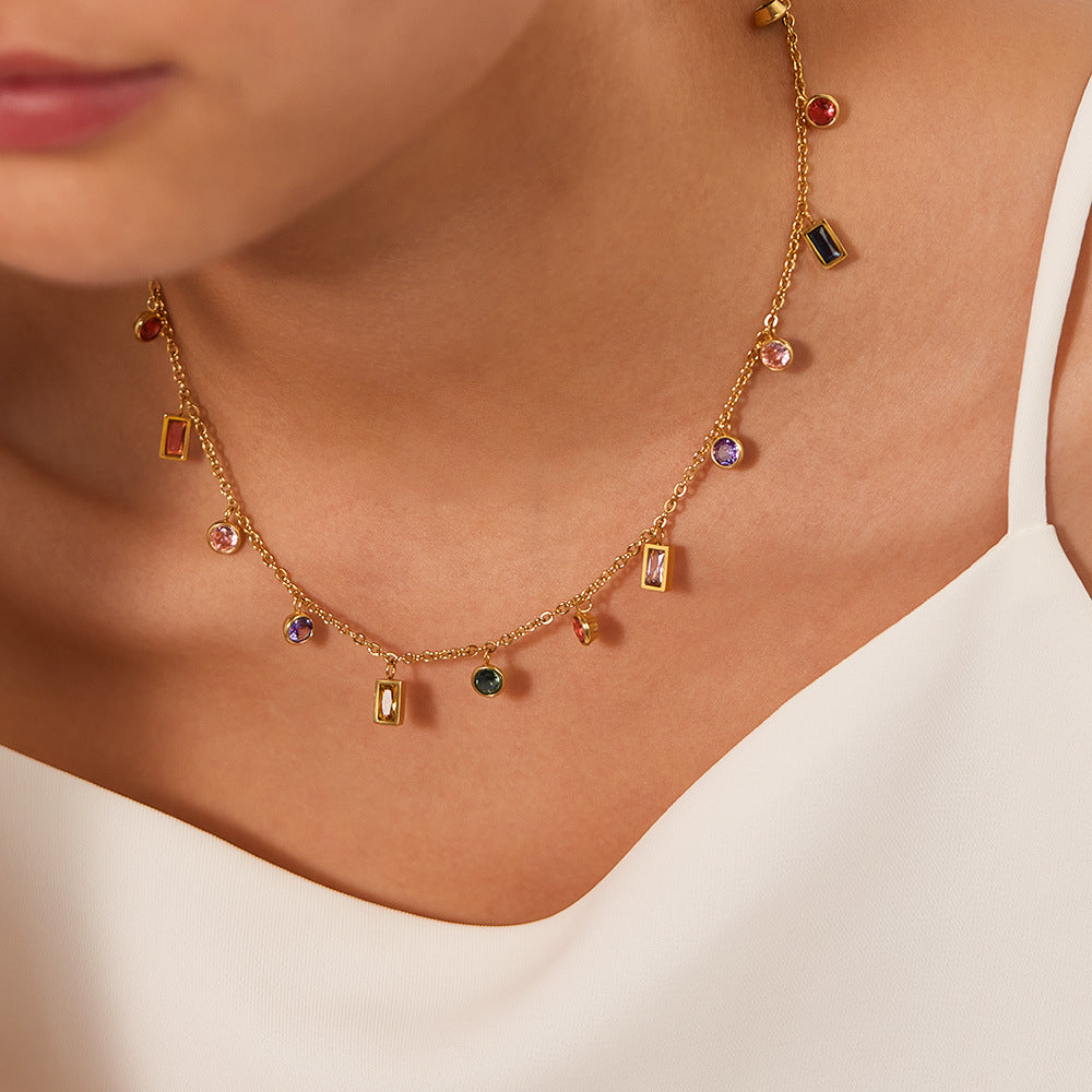 Gold necklace with colorful gemstones worn by a person