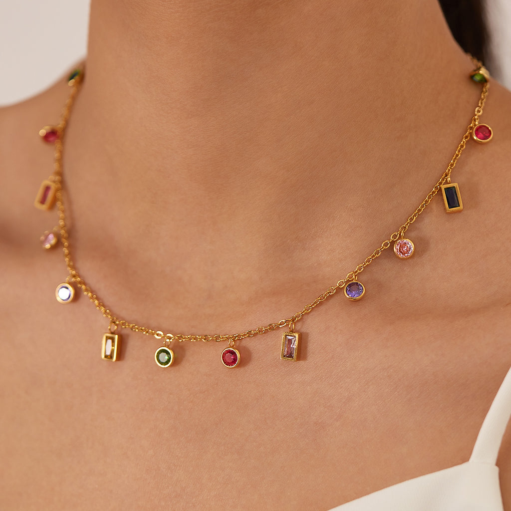 Gold necklace with colorful gemstones on a person's neck