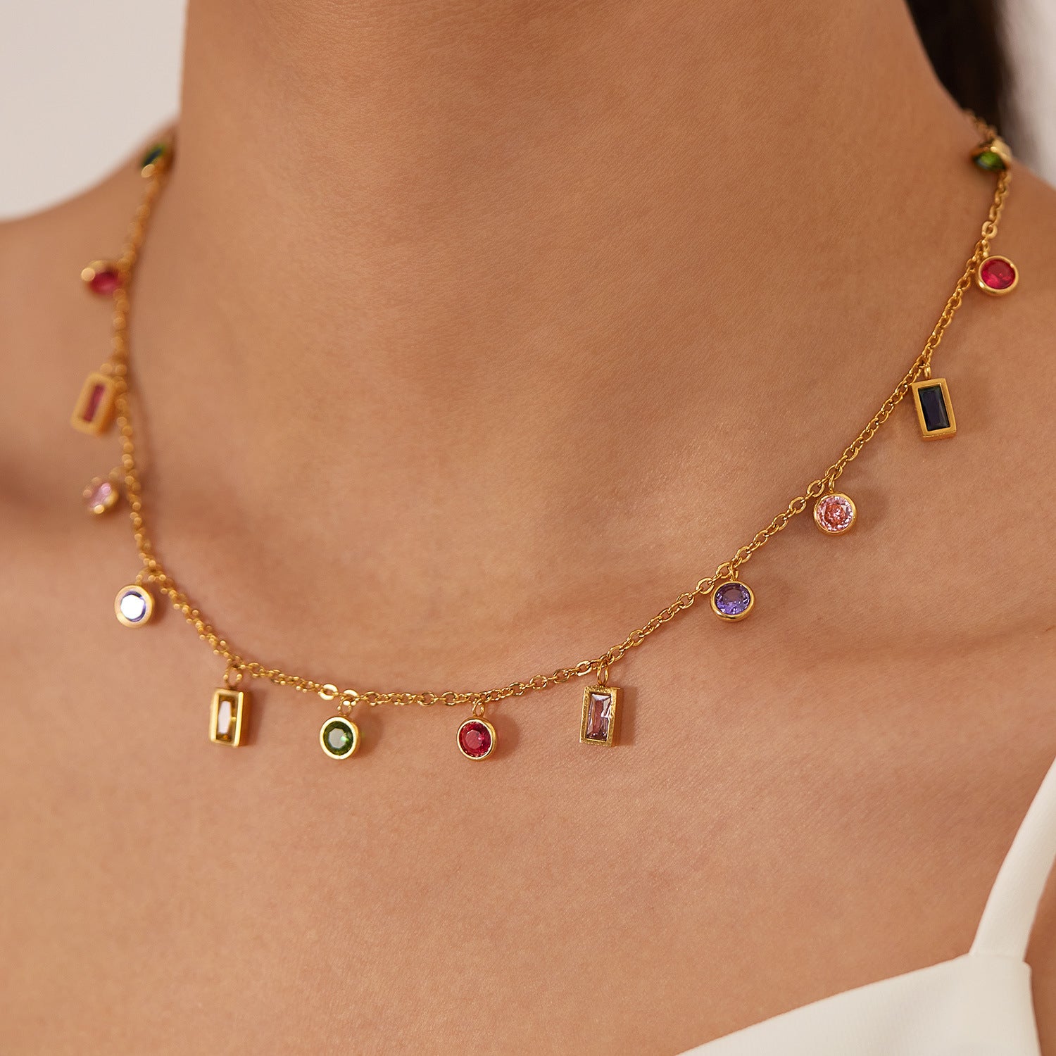Gold necklace with colorful gemstones on a person's neck