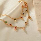 Gold necklace with colorful gemstones on a beige fabric background