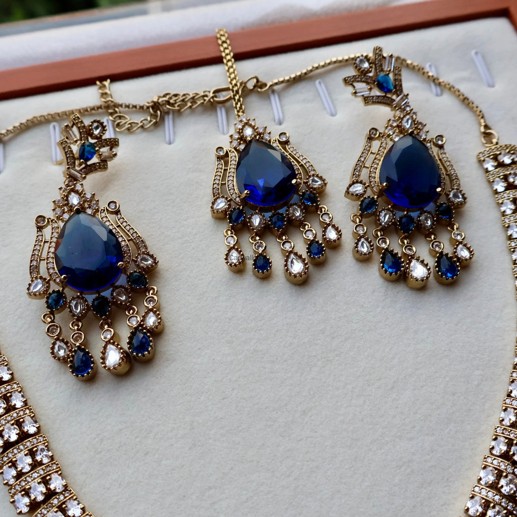 Gold and blue gemstone necklace on a white cushion