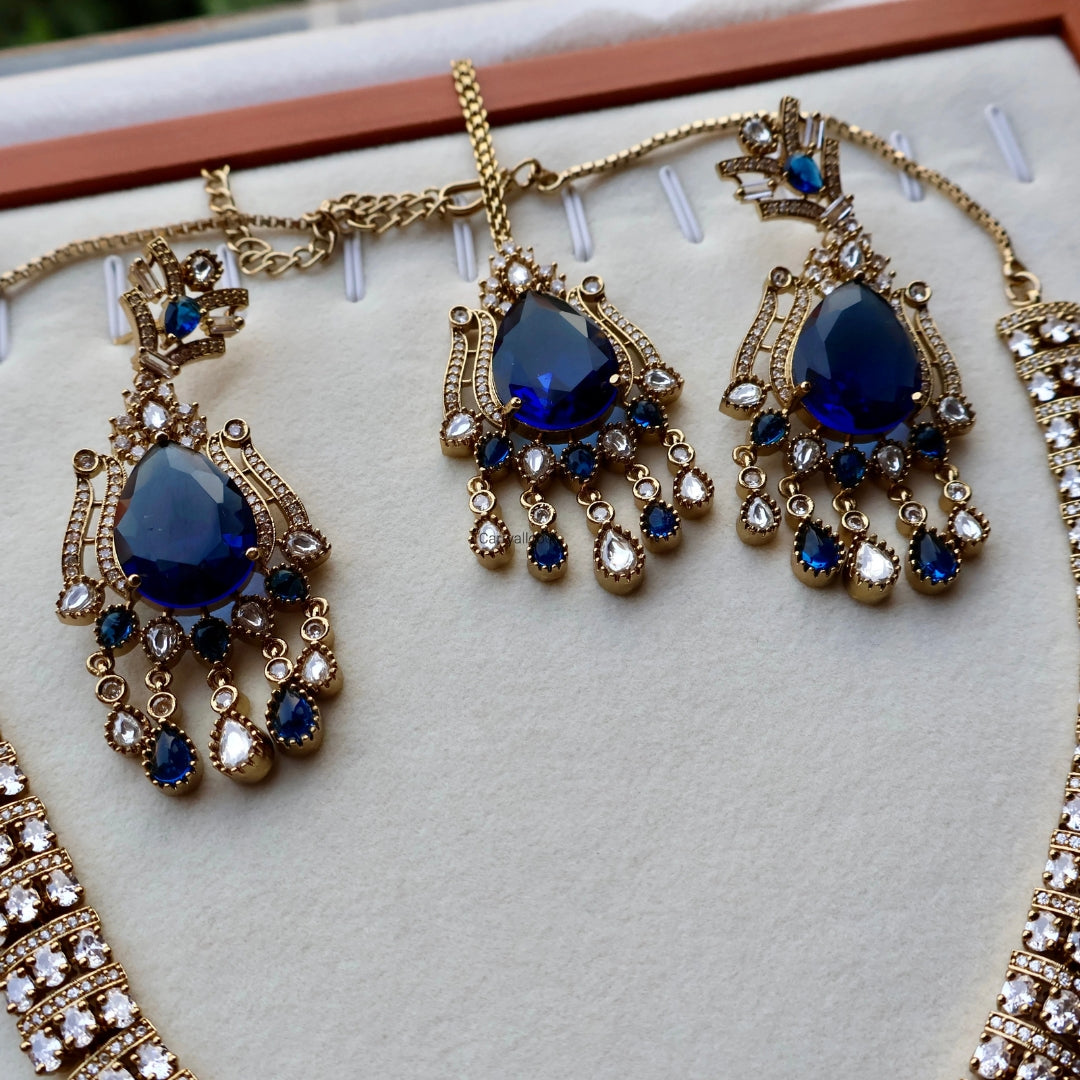 Gold and blue gemstone necklace on a white cushion