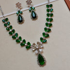 Green gemstone necklace and earrings on a beige background
