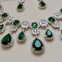 Necklace with green teardrop-shaped gemstones and silver accents on a light background