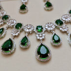 Necklace with green teardrop-shaped gemstones and silver accents on a light background