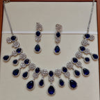 Jewelry set with blue stones and silver accents on a beige background