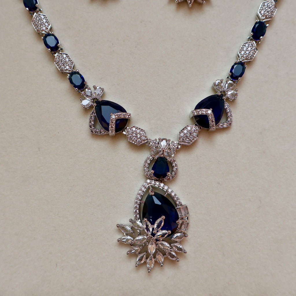 Necklace with blue gemstones and silver accents on a beige background