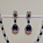 Pair of blue gemstone earrings on a beige background