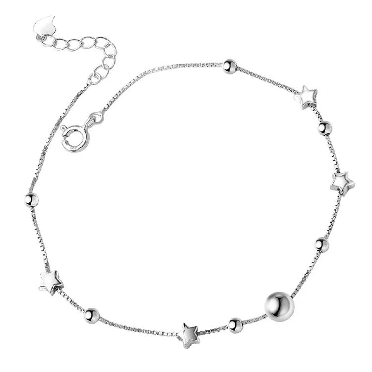 Silver bracelet with star and moon charms on a white background