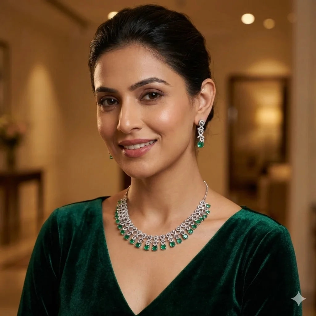Woman wearing a green dress and jewelry set with a blurred indoor background