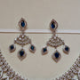 Pair of silver earrings with blue gemstones on a beige background