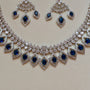 Silver necklace with blue stones and matching earrings on a light background