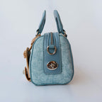 Light blue handbag with a metal clasp on a white background