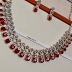 Necklace with red gemstones and silver accents on a white stand with 'CARRYALCO' branding.