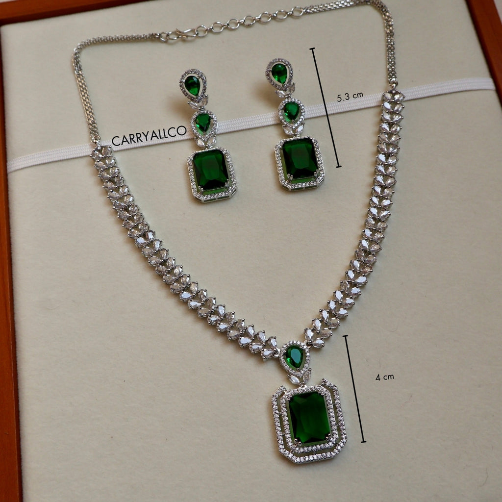 Jewelry set with necklace and earrings featuring green gemstones on a CARRYALCO branded card.