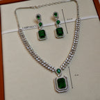 Jewelry set with necklace and earrings featuring green gemstones on a CARRYALCO branded card.