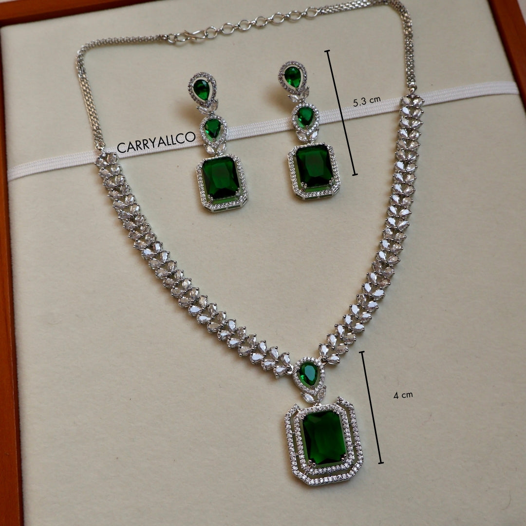 Jewelry set with necklace and earrings featuring green gemstones on a CARRYALCO branded card.